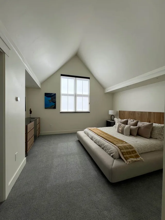 Vaulted loft bedroom with a king bed and mountain artwork