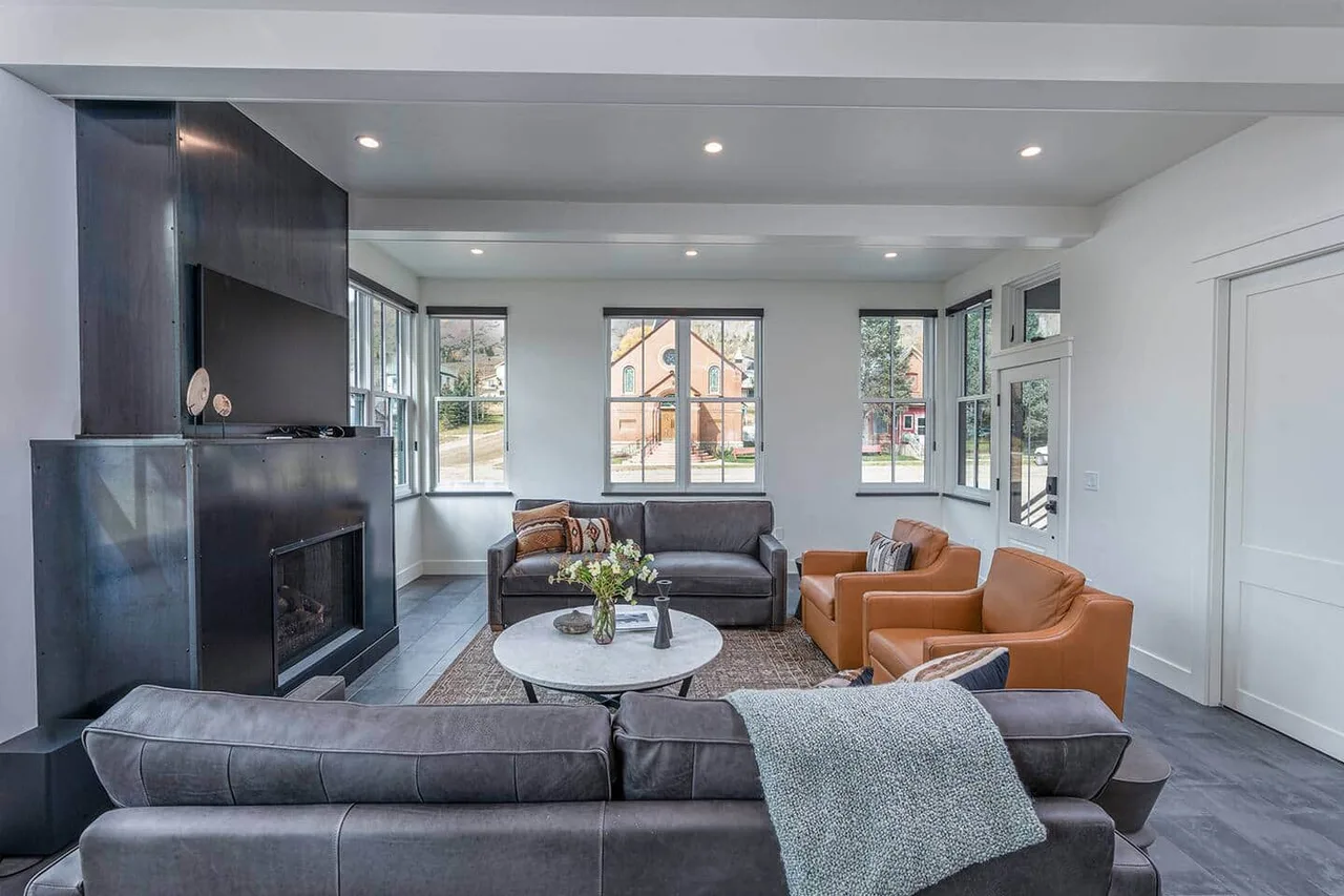 Main-level living room with a steel gas fireplace and San Juan views